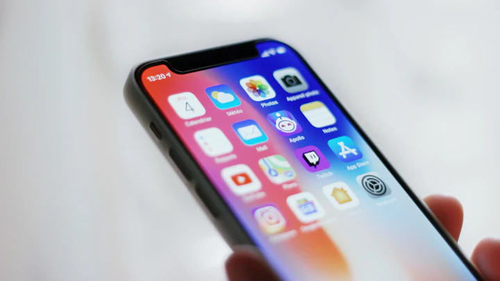 Mão segurando um smartphone com a tela de aplicativos aberta